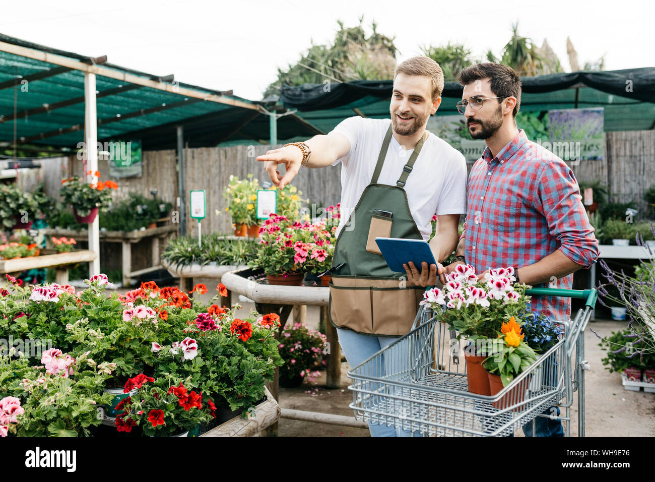 Worker with tablet in a garden center advising customer Stock Photo