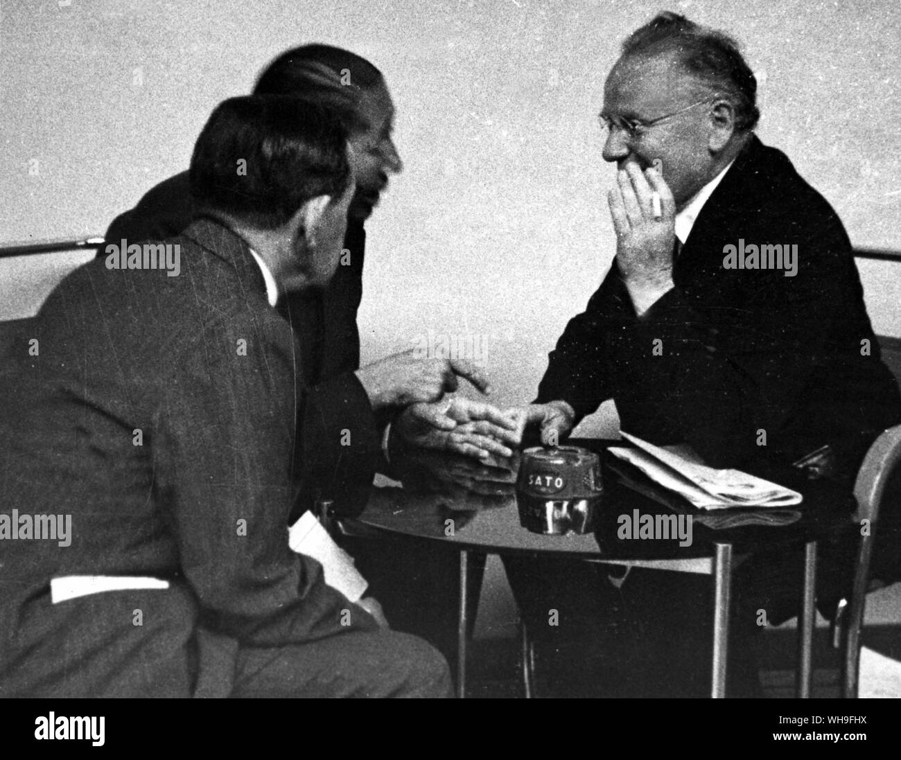 30th June 1936: An informal glimpse of Ministers off duty at Geneva, during intervals of the present league session. M. Titulescu (Romania) in the centre, chats earnestly with M. Litvinoff (Russia), right and another delegate.. Stock Photo
