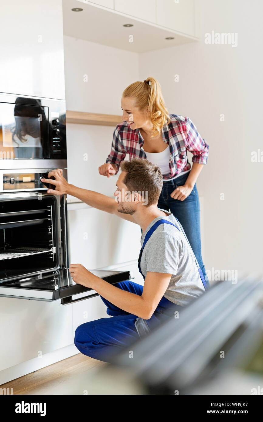 Craftsman installing new oven in kitchen Stock Photo