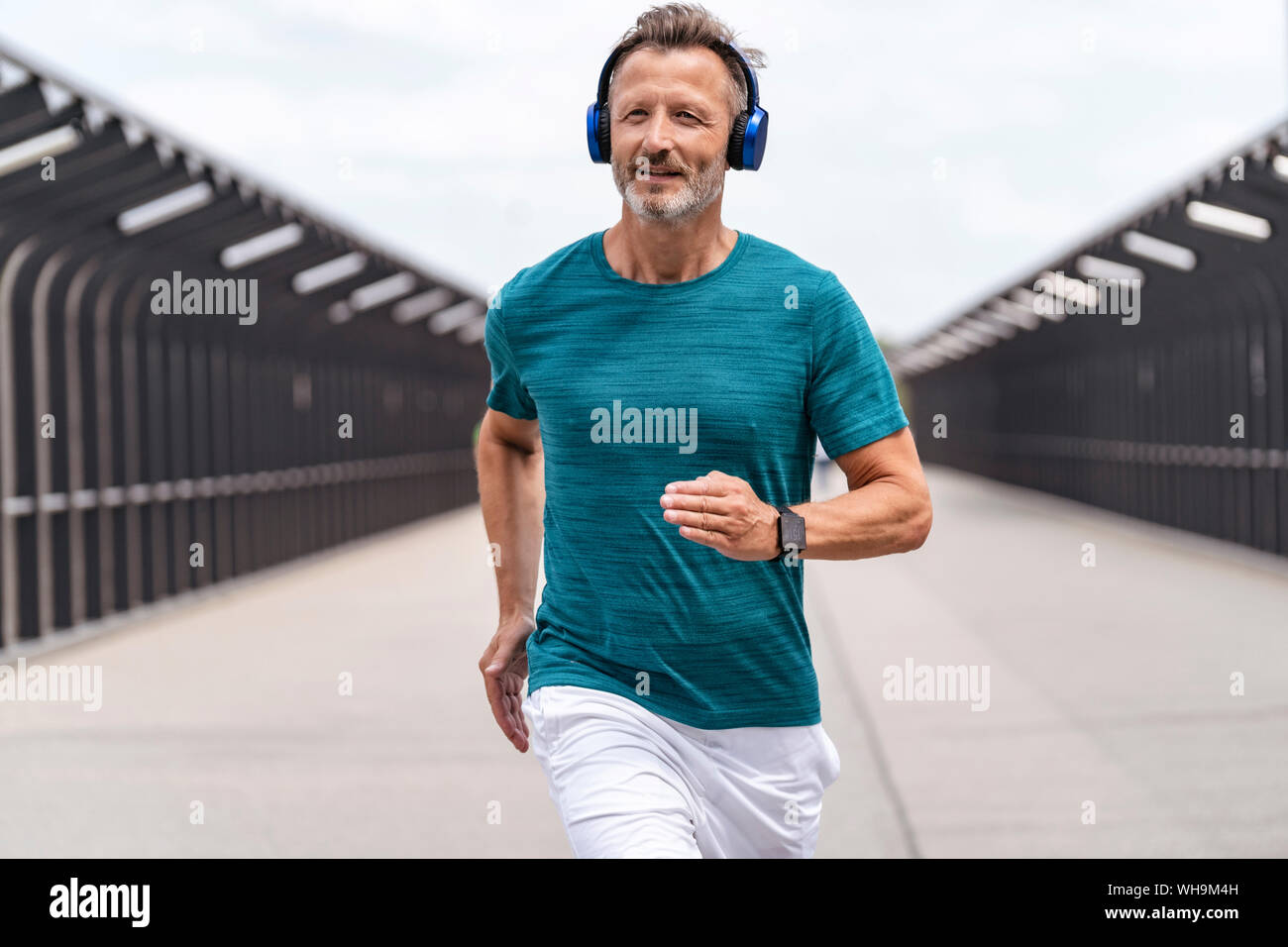 Sporty man wearing headphones and jogging Stock Photo Alamy