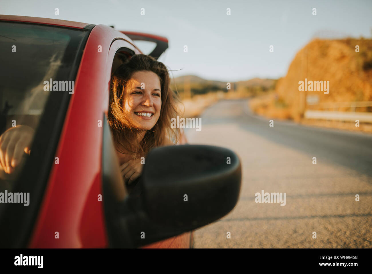 Woman on a road trip looking out of car window Stock Photo - Alamy