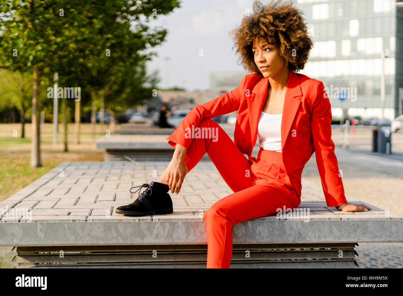 Portrait of young woman wearing fashionable red pantsuit Stock Photo