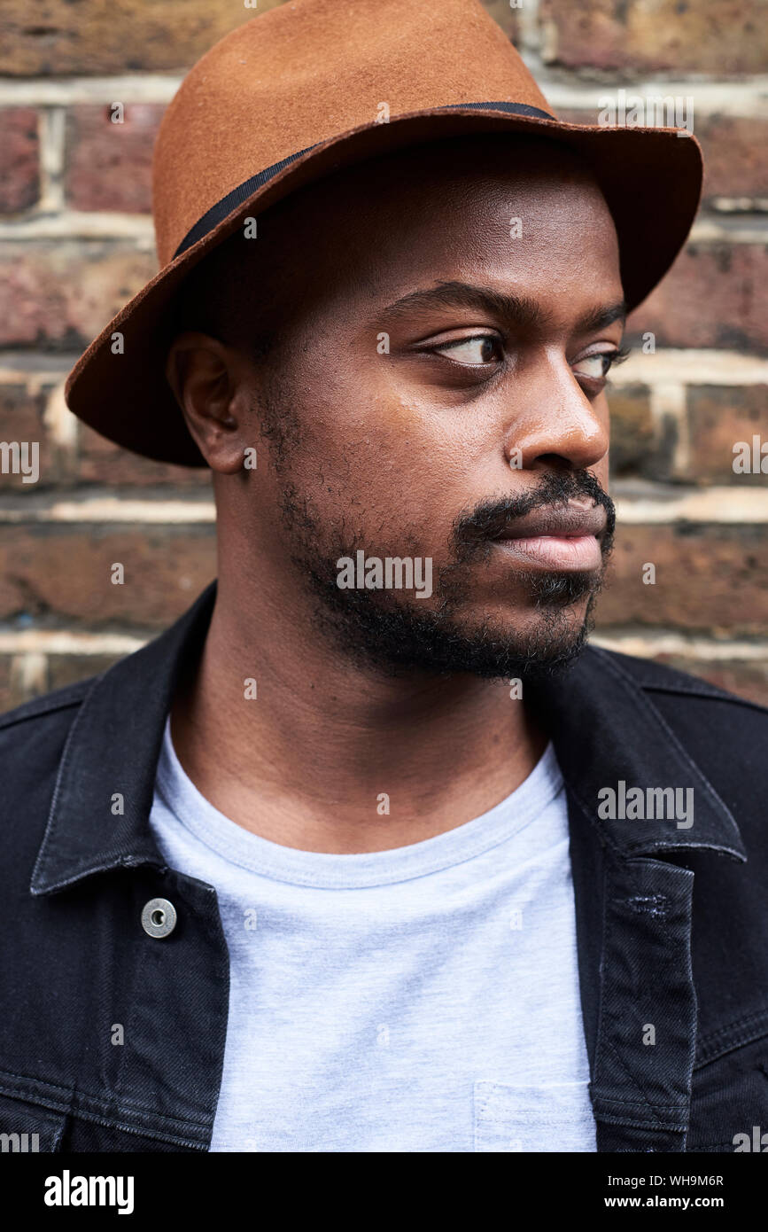 Portrait of mid adult man wearing brown hat looking sideways Stock Photo