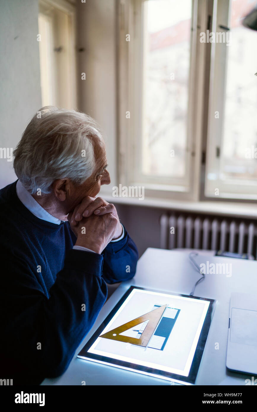 Senior man using tablet with architectural plan Stock Photo