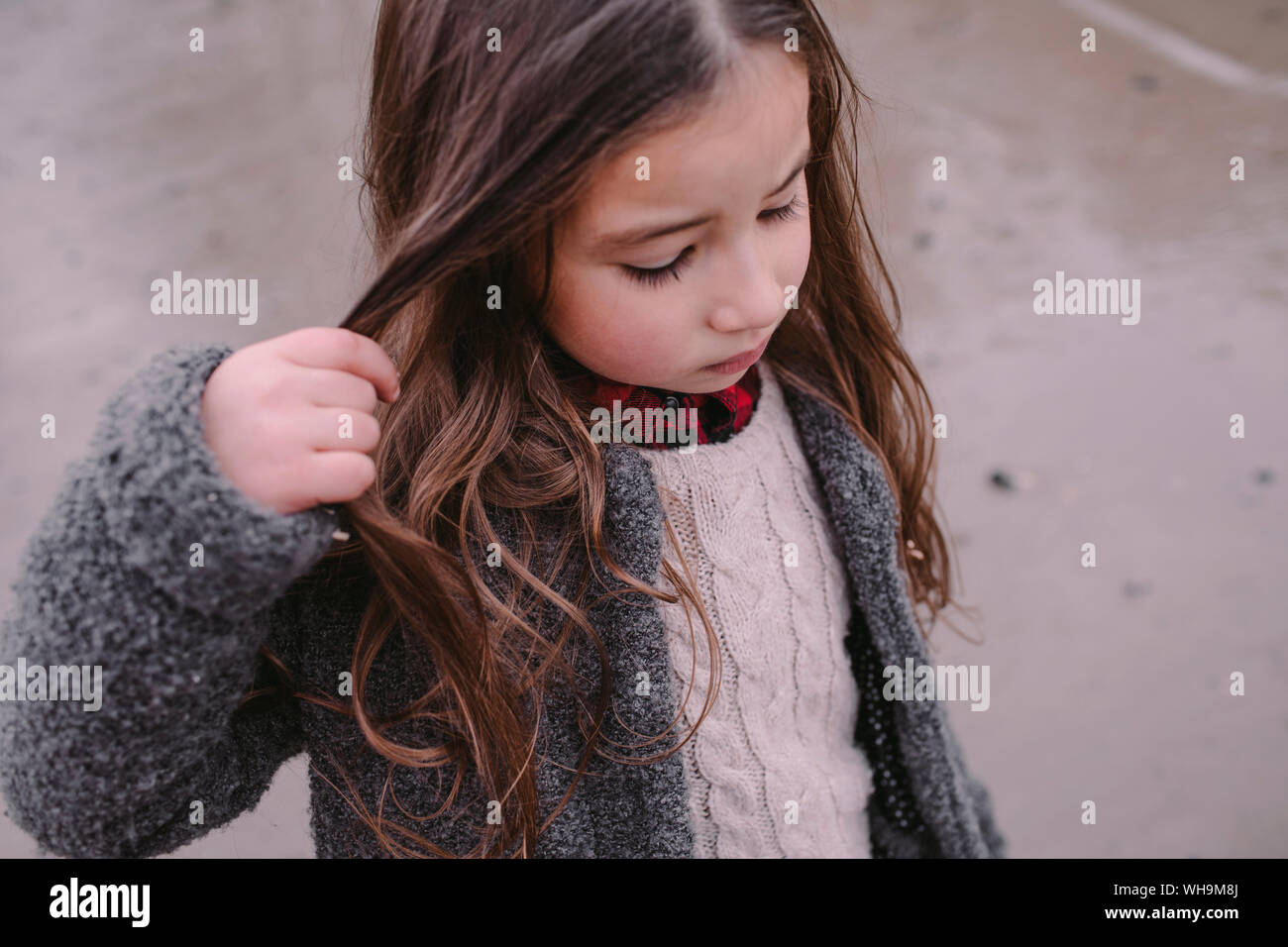 Portrait of little girl with hand in her hair Stock Photo