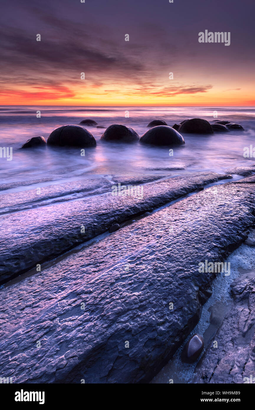 The Moeraki Boulders with dramatic sunrise at Moeraki Beach, Otago, South Island, New Zealand, Pacific Stock Photo