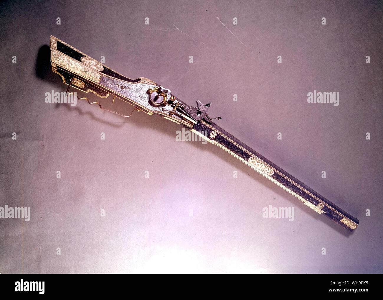 Wheel lock Rifle ornamented over its whole surface. The barrel and lock plate are engraved with the Virtues and figures emblematic of abundance amidst floral scrolls while the stock is veneered with carved ebony enclosing panels of carved staghorns Stock Photo