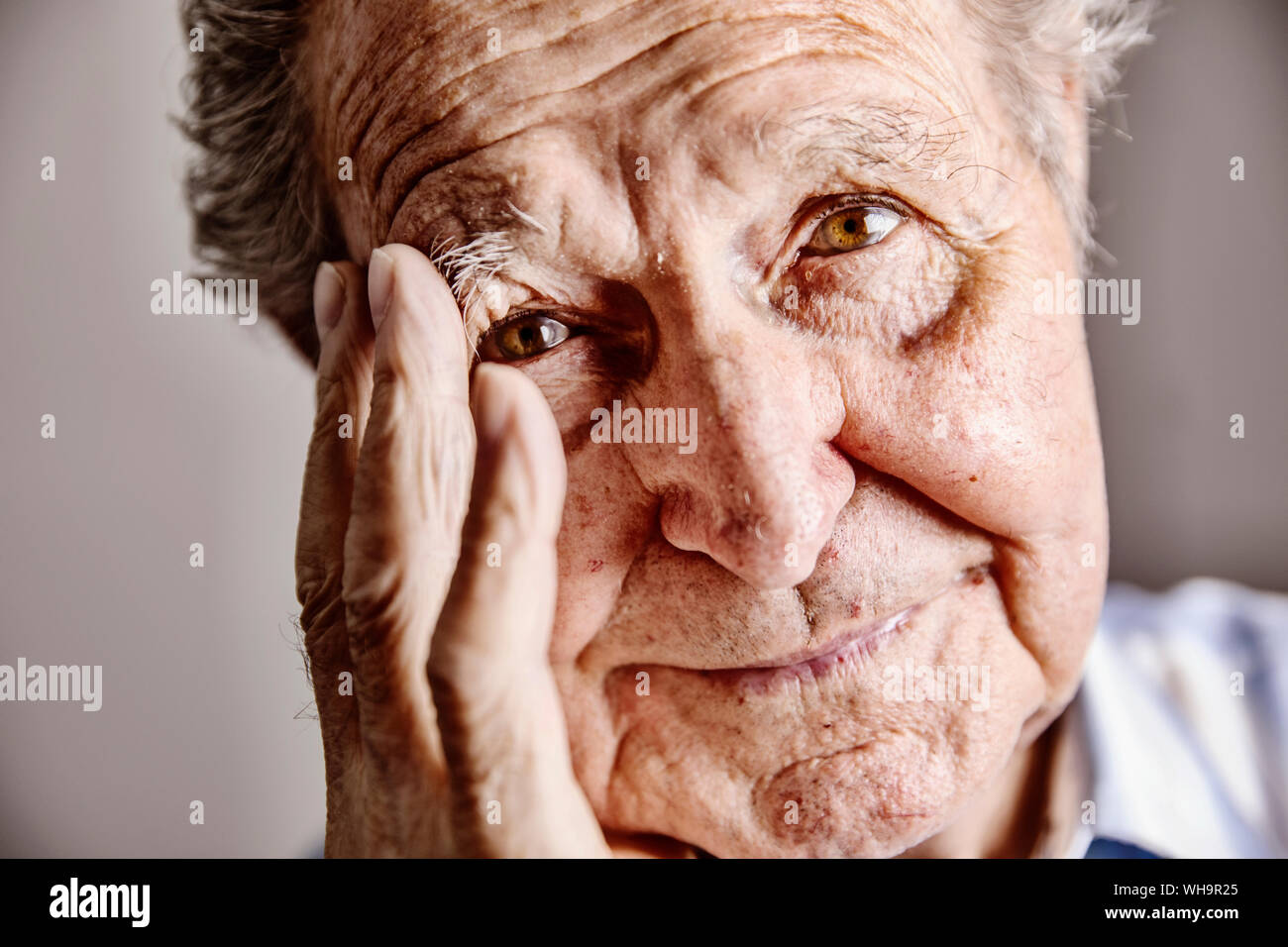 Portrait of senior man with hand on face, close-up Stock Photo