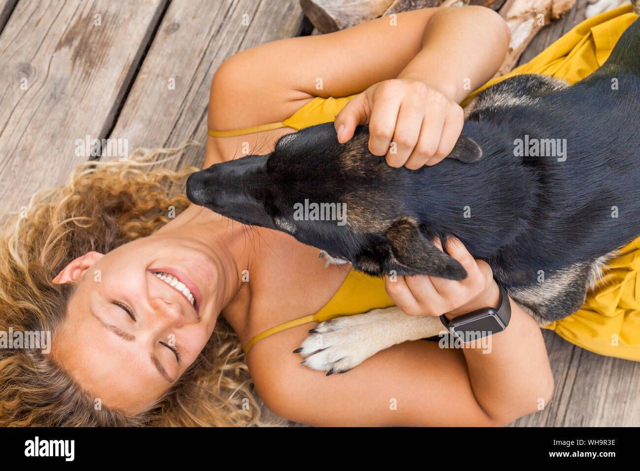 Husky shepherd mongrel dog and his mistress lying on wooden board Stock Photo