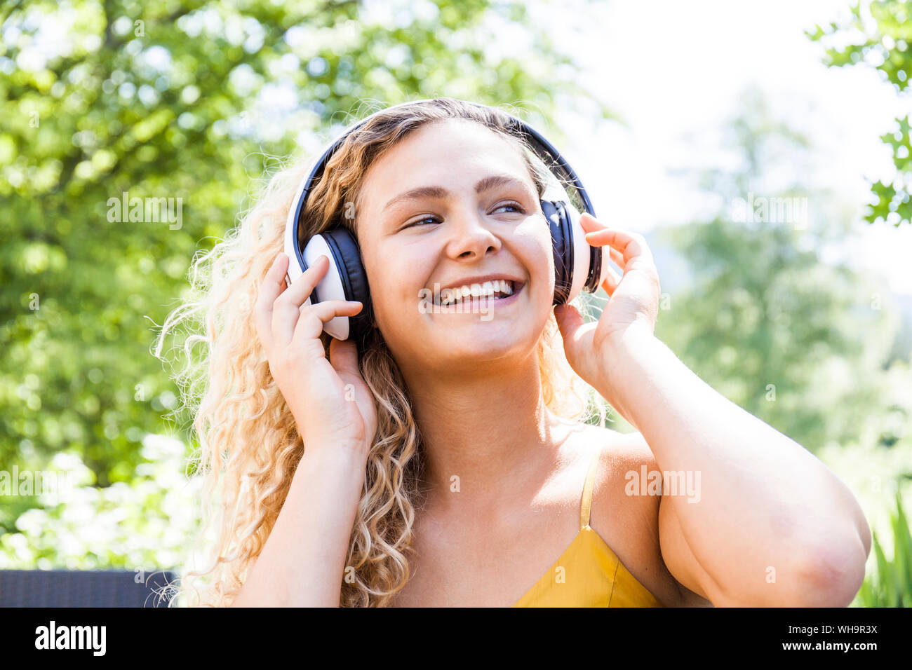 Smiling woman listening to music outdoor Stock Photo