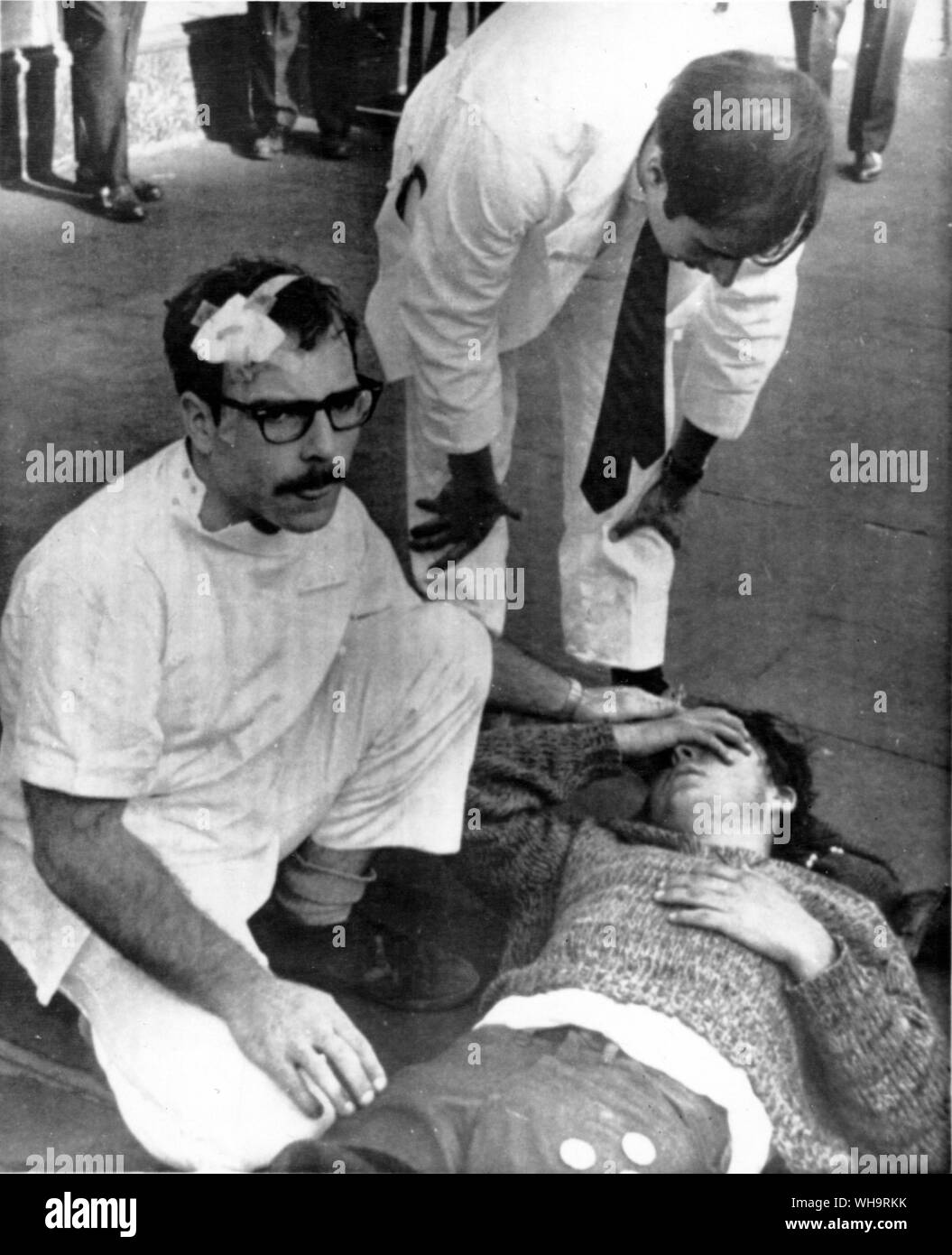 October 18th 1967: Oakland, California. An intern, his own head bandaged comforts an anti-draft protester after the police cleared the street in front of Oakland Army Induction centre. Stock Photo