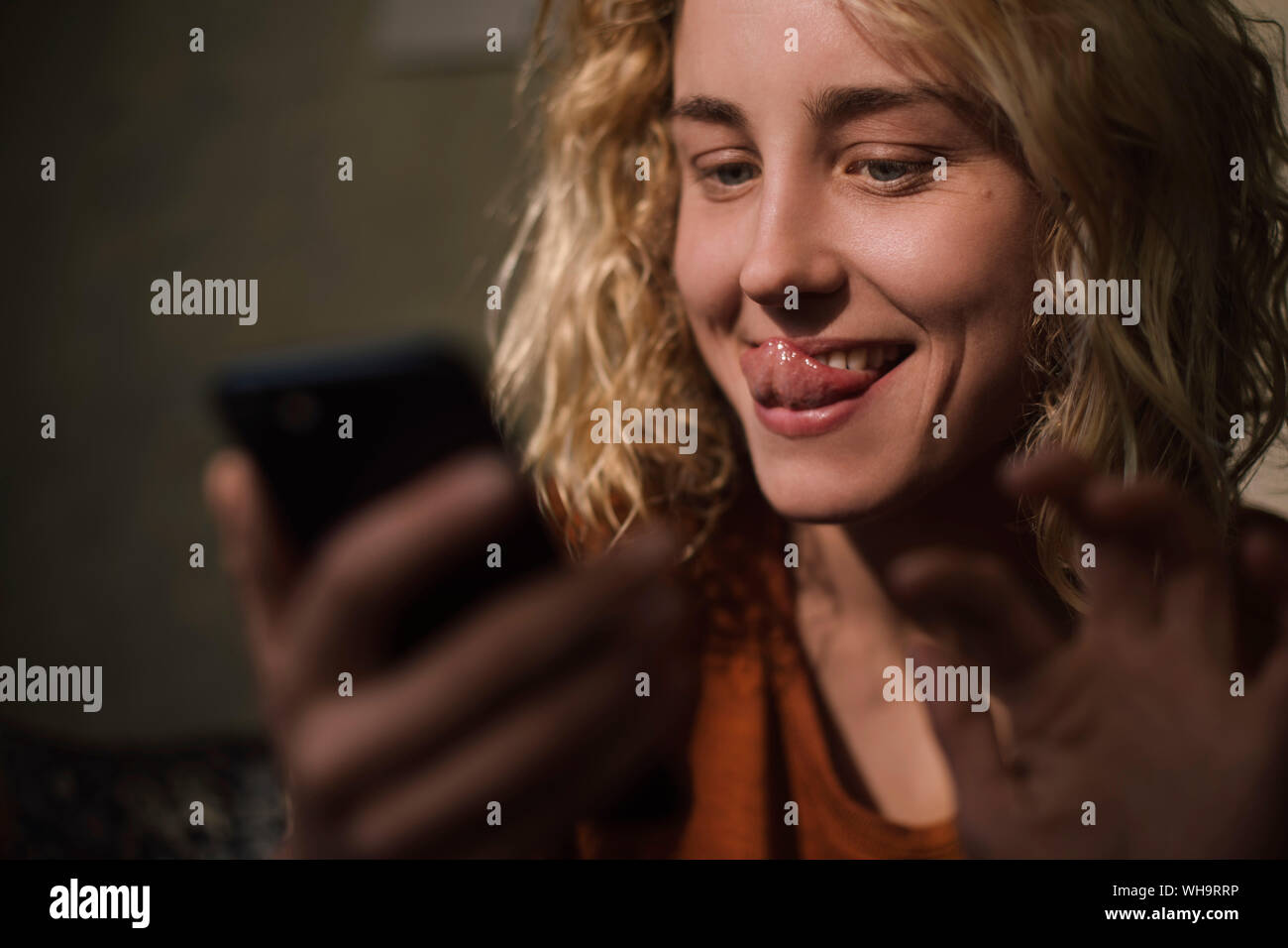 Portrait of blond young woman using cell phone for video chat Stock Photo