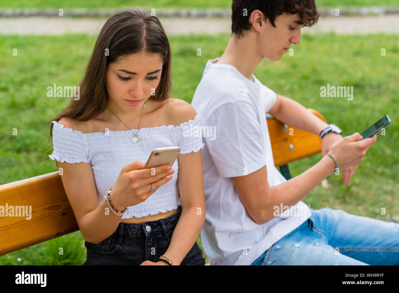 Young couple using smartphone in a park Stock Photo