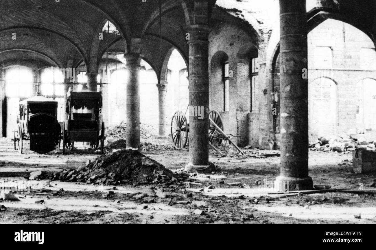 WW1: Northern France: Damage to church hall, Ypres, showing an allied cannon. 1915. Stock Photo