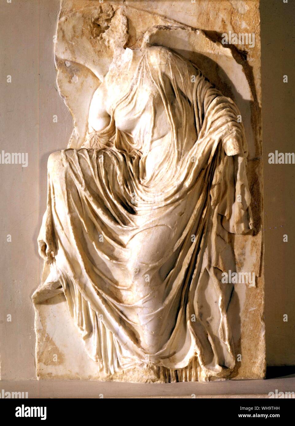 A small temple of Athena Nike had a narrow path between it and a considerable drop. This was dangerous for crowds and a balustrade was added on the outside of which were reliefs, including this one. Nike is loosening her sandle in order to bring the victory offering barefoot. Stock Photo