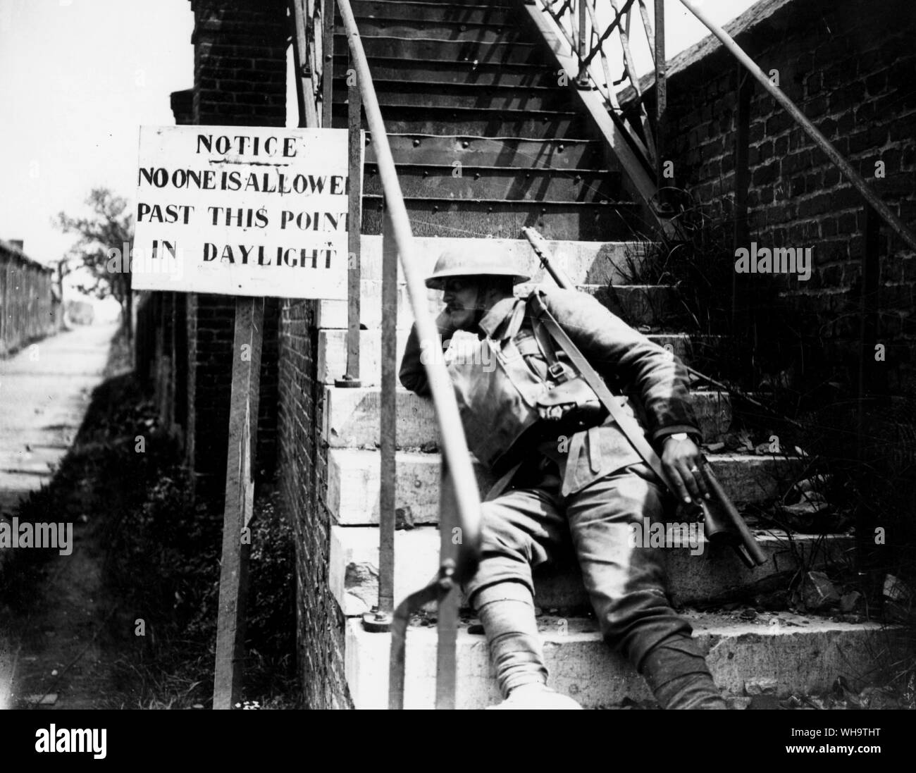 WW1/France: Battle of the Lys. A 2nd Scottish Rifles sentry in Lievin by a notice saying that no one is allowed past this point in daylight, May 1918. Stock Photo