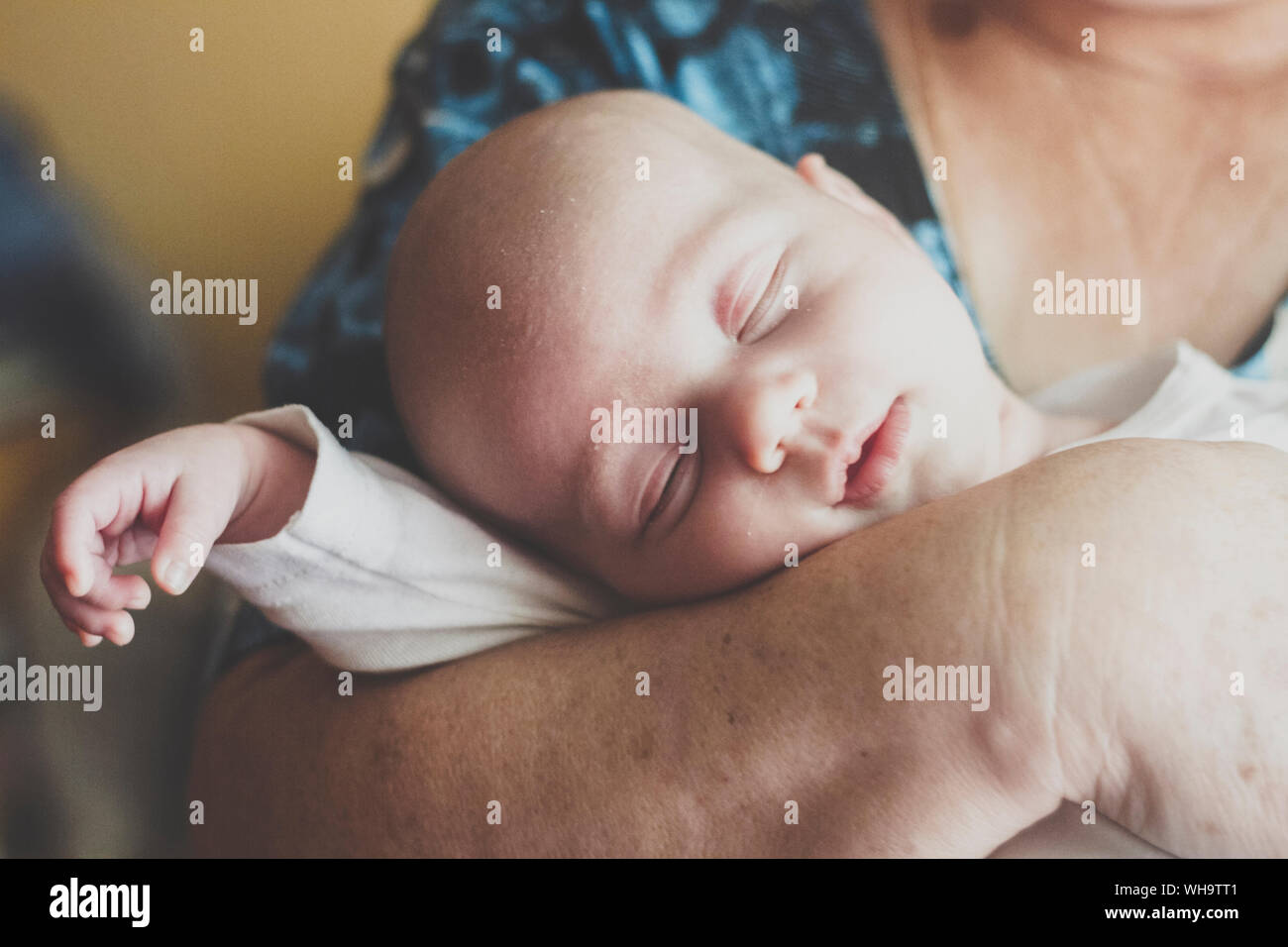Portrait of baby boy sleeping in grandmother's rams Stock Photo
