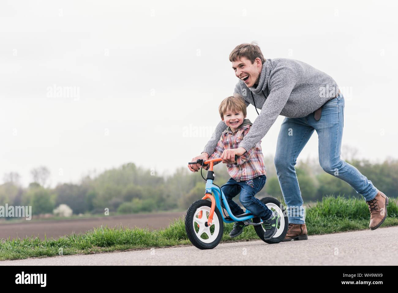 Learning to ride a bike with parents hi res stock photography and