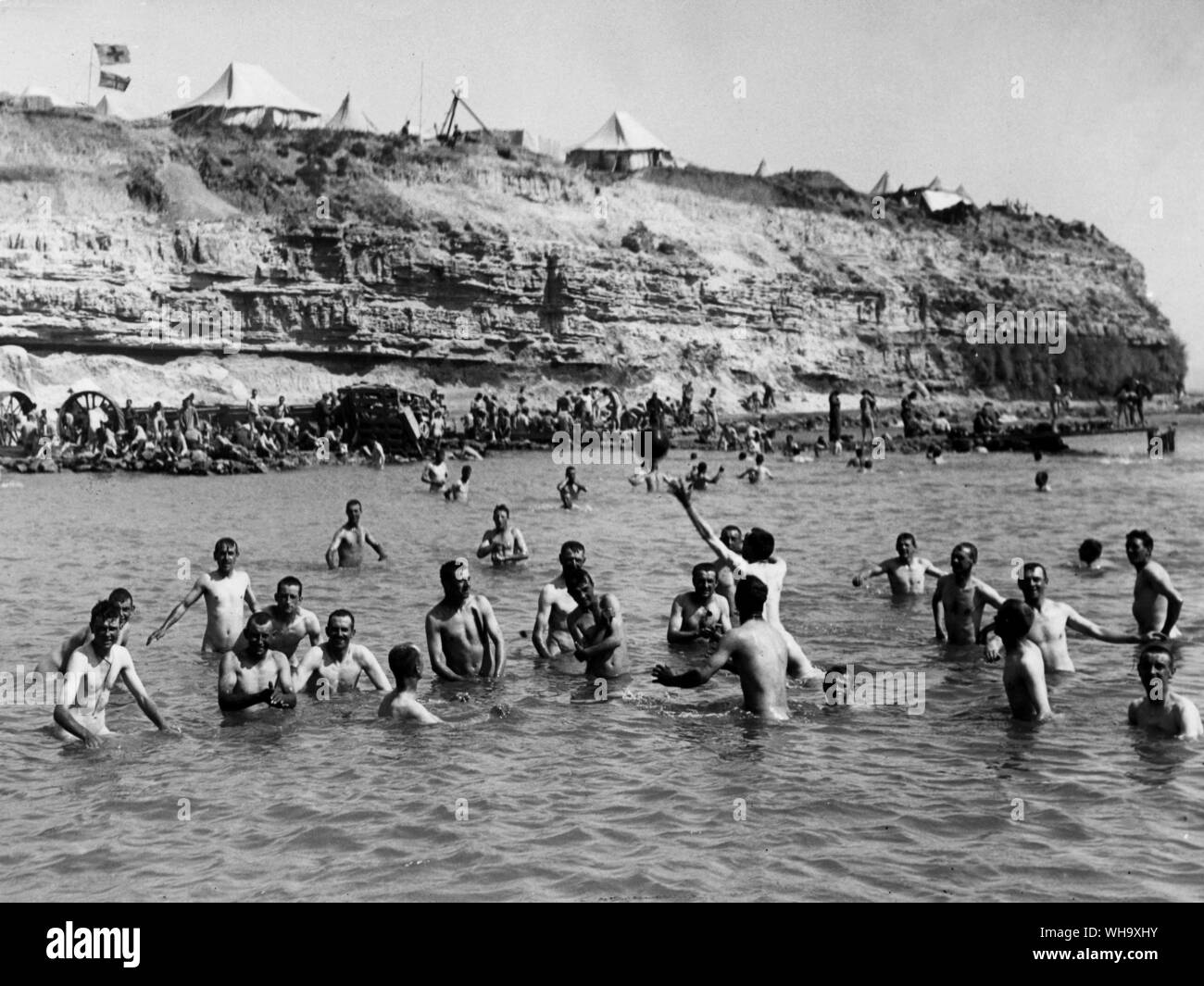 WW1: Men bathing south of X beach, Helles Front. On the cliff top are the tents of No.87 Field Ambulance, 29th Division. Stock Photo
