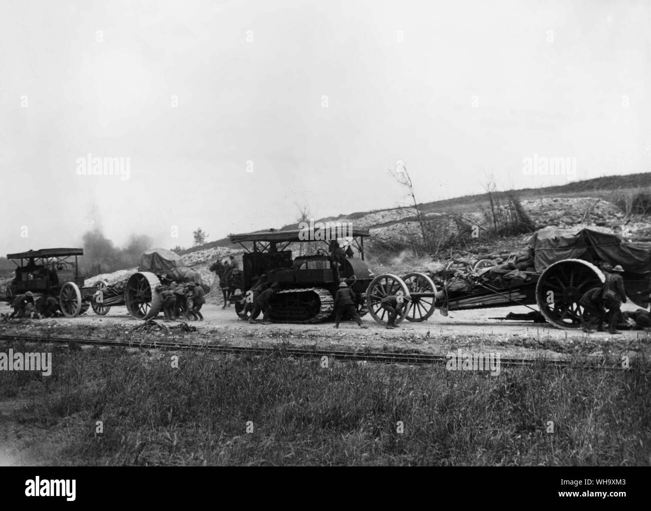 WW1: Battle of the Somme, 1916. Tractors bringing up 8-inch Howitzer guns. Soldiers taking cover behind them from shell burst seen on the far side of the road. Death Valley, near Mametz, July 1916. Stock Photo