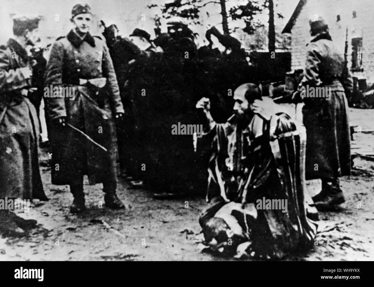 WW2: German Nazi soldiers humiliate a Jewish rabbi in Poland. Stock Photo