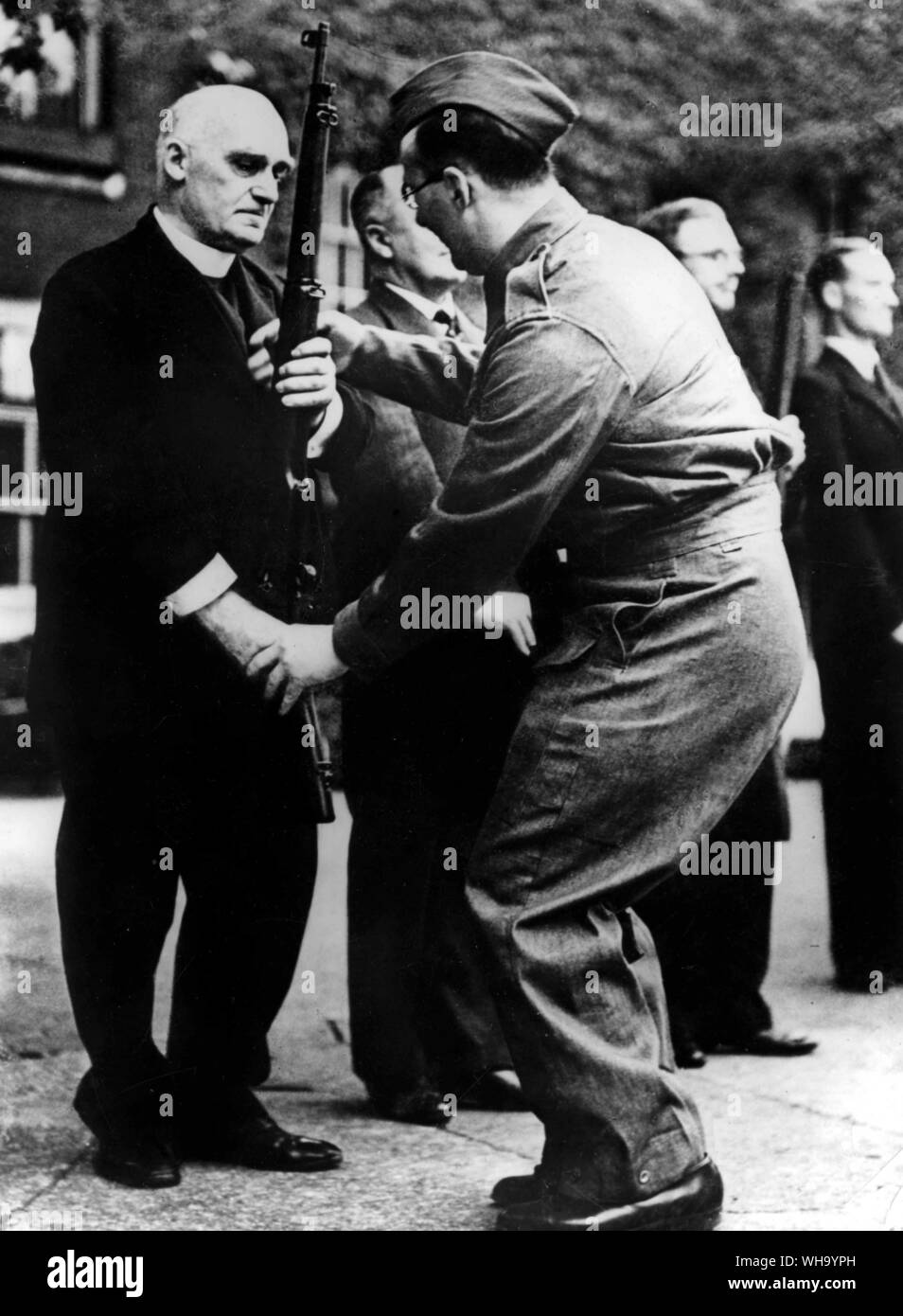 WW2: Members of both the House of Lords and the Commons are now being put through their paces as members of the local defence volunteers in the playground of Westminster School. Photo: Dr Jocelyn Perkins, Sacrist to Westminster Abbey, who is an L.D.V seen being instructed in rifle drill by a senior L.D.V. member. Stock Photo