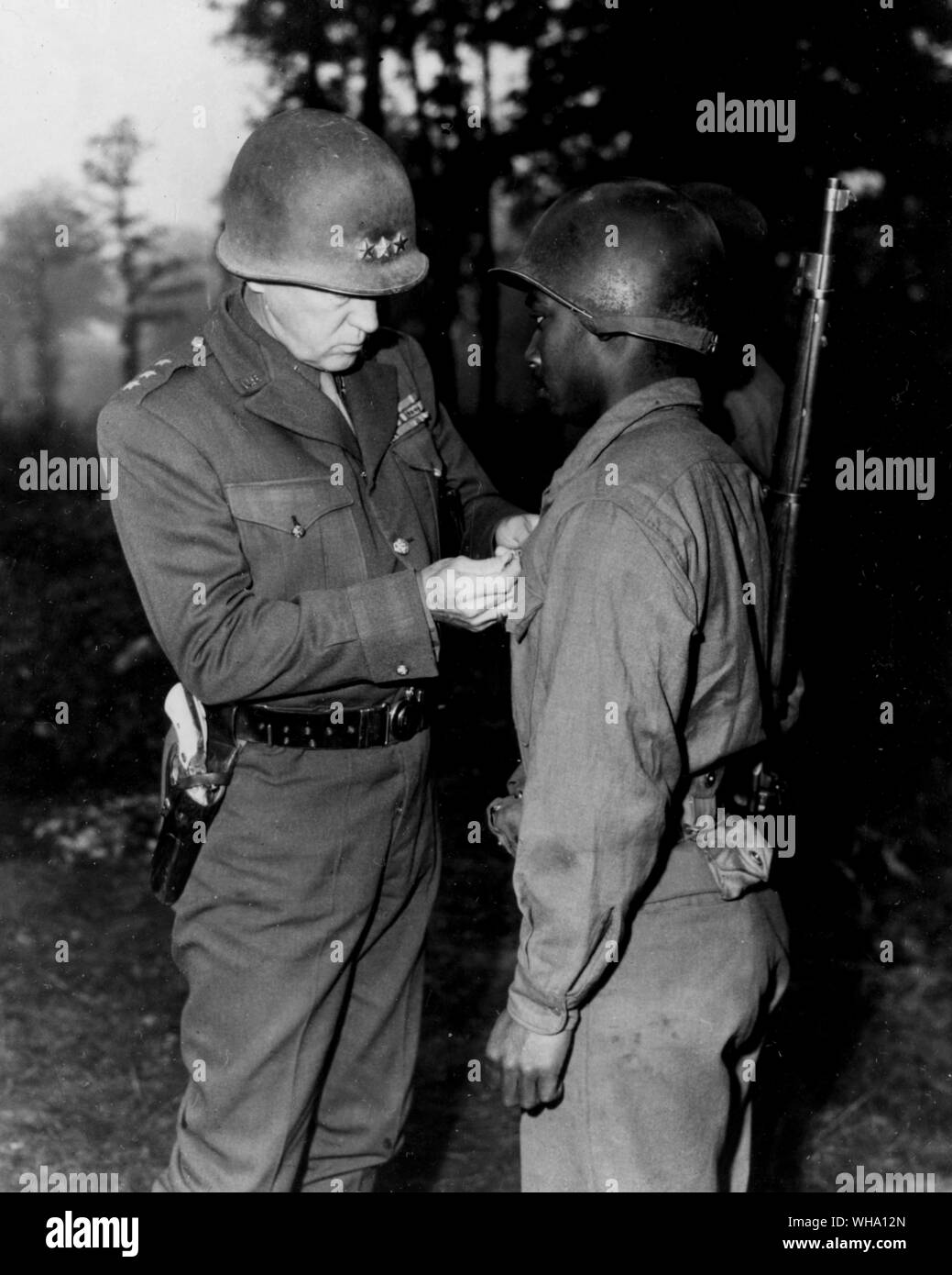 WW2: Lt. Gen. George S. Patton decorates a US Army soldier with the silver star, 1944. Stock Photo