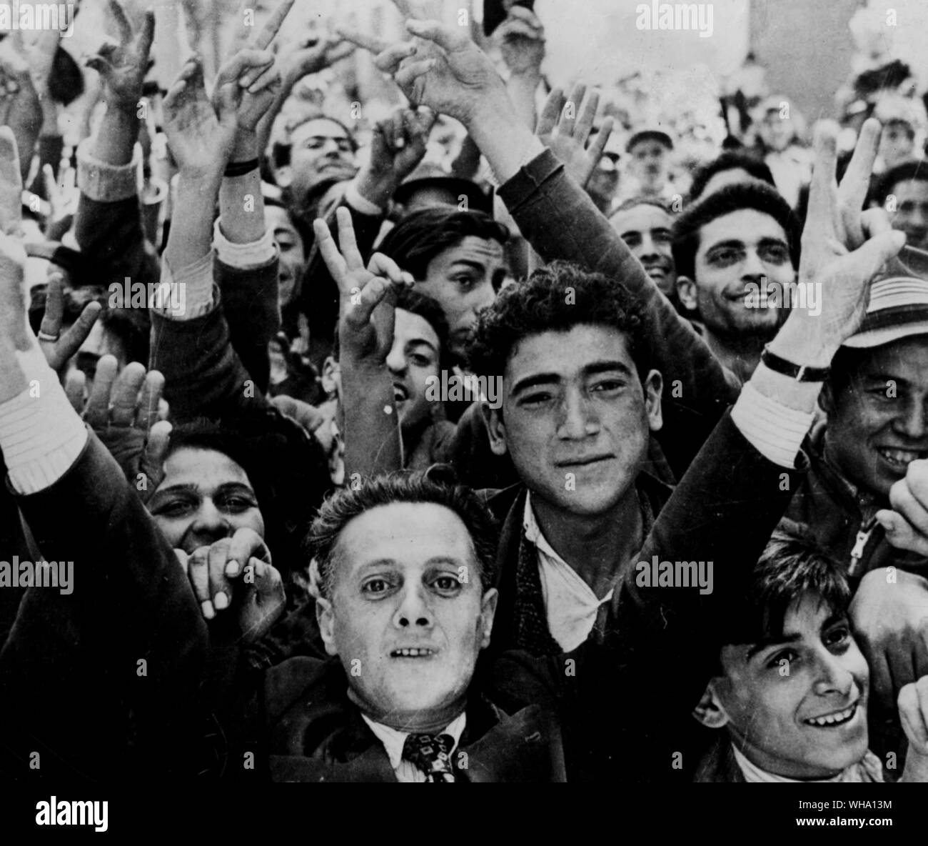 WW2: Civilians in Tunis give V-sign as they throng the streets to welcome allies on their entry into the city. Stock Photo