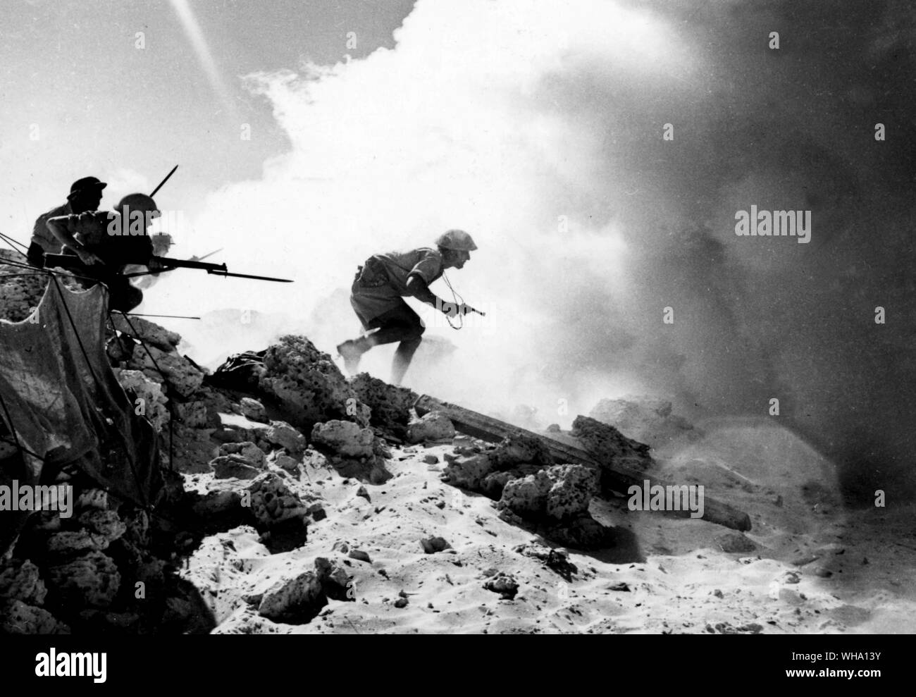 WW2: Australians approach a strongpoint ready to rush the enemy from different sides, using a smokescreen. Stock Photo