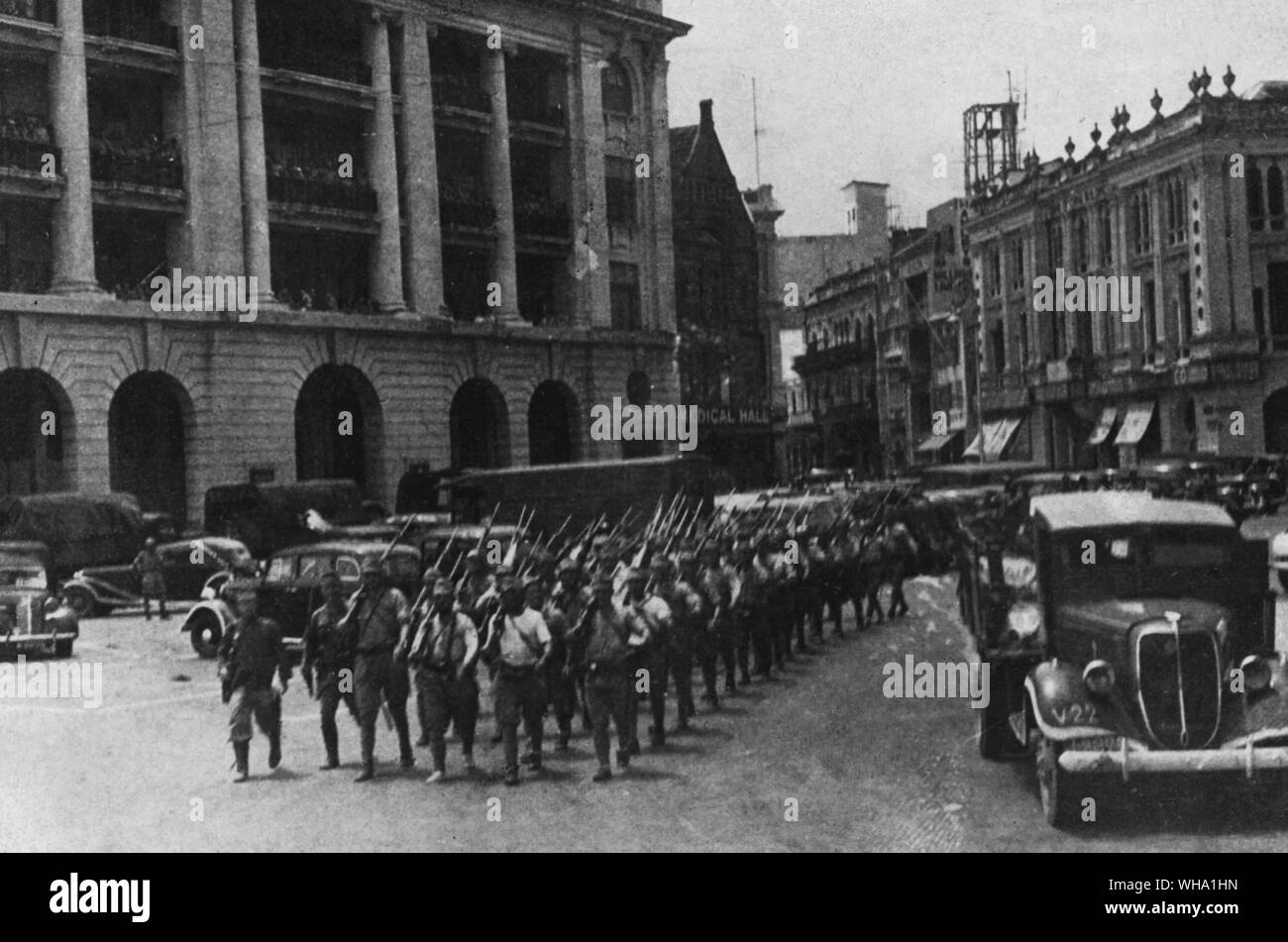 WW2: Japanese troops parading near Raffles Place, Singapore. 1942 Stock Photo