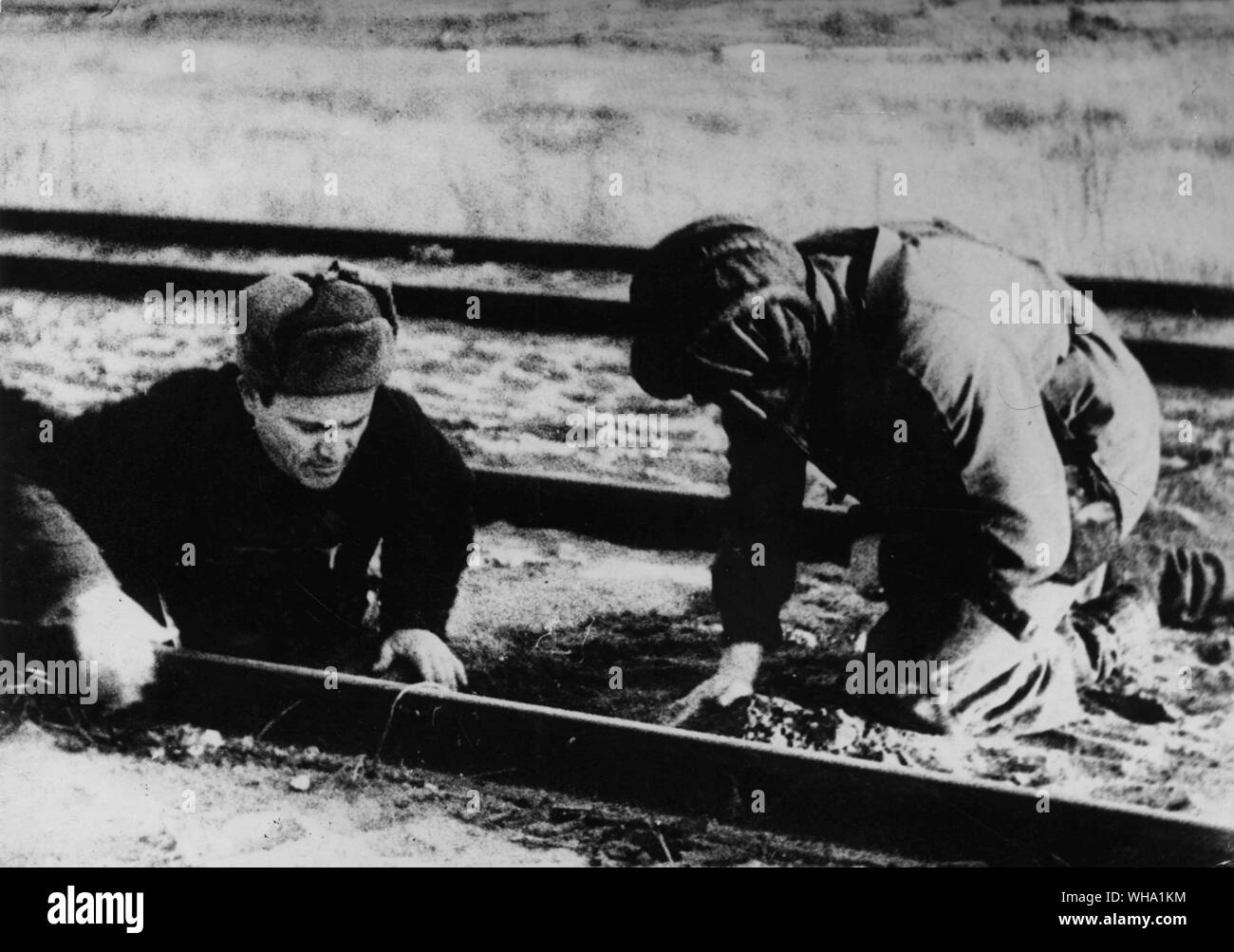 WW2: Belorussian partisans mining a railway track. Mines attached to a railway track. Stock Photo
