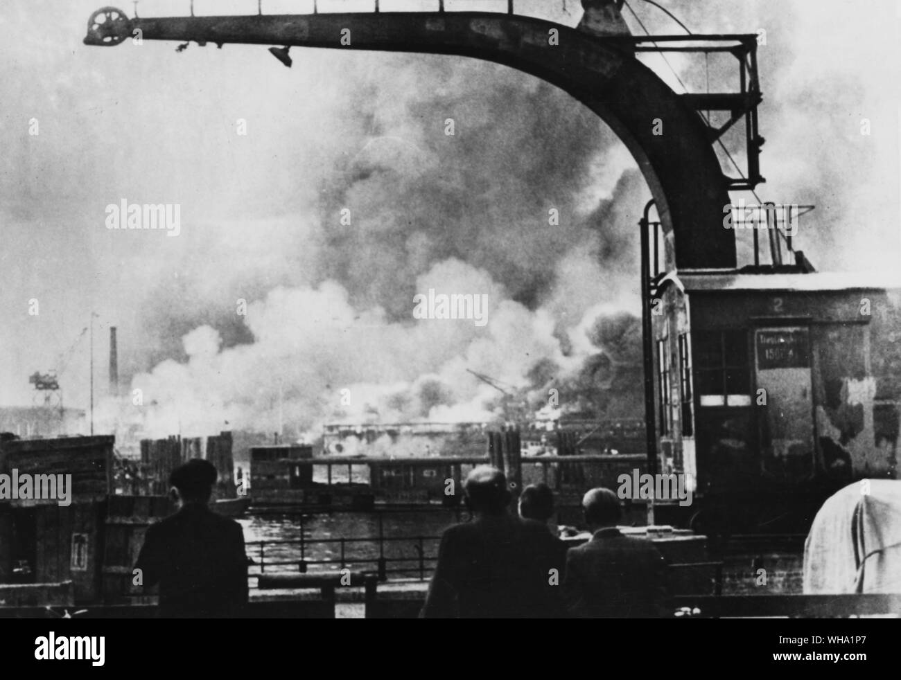 WW2: Flames and smoke fill the sky around the German works where submarines were under construction of their war-machine. 8th August 1944. Captured German photo. Stock Photo