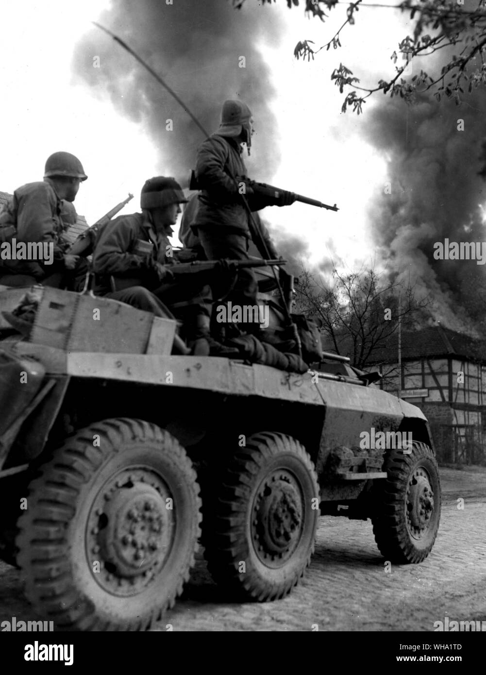 WW2: Infantrymen of the US 9th Army, 19th Corps, 30th Infantry Division, poised for action atop an army reconnsiance car, entering the German town of Bonn. The town was captured and the drive to Elbe continued. April 13th 1945. Stock Photo