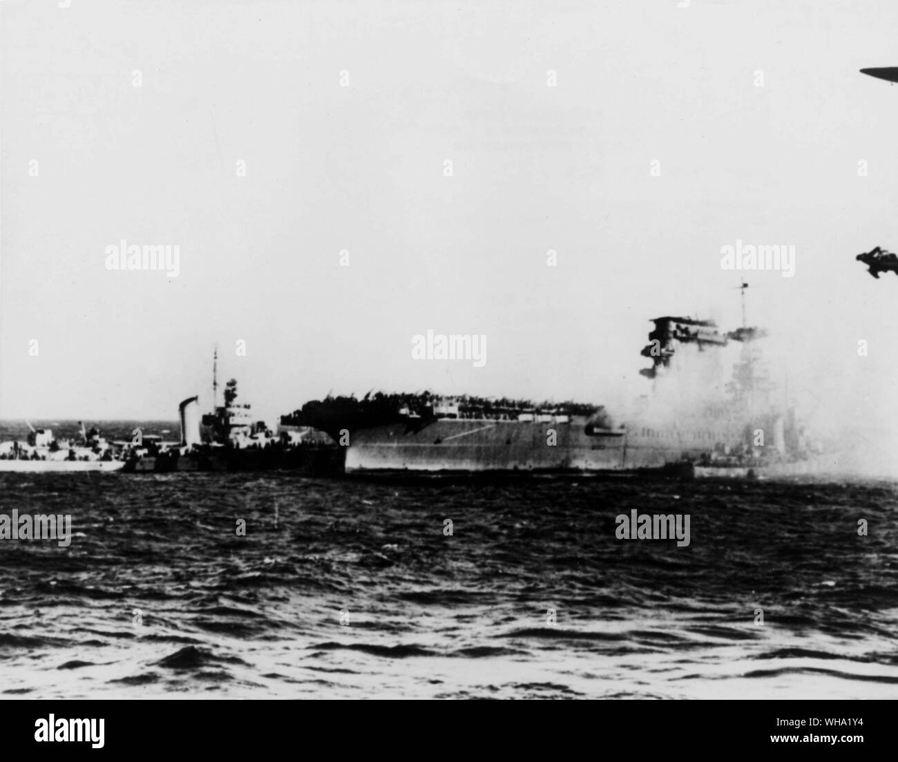 WW2: Pacific Ocean. Destroyers remove crewmen of the aircraft carrier USS Lexington (CV-2) following the battle of the Coral Sea. The attempt is being made to pump water from the destroyer along the starboard side to the fires on the carrier. Stock Photo