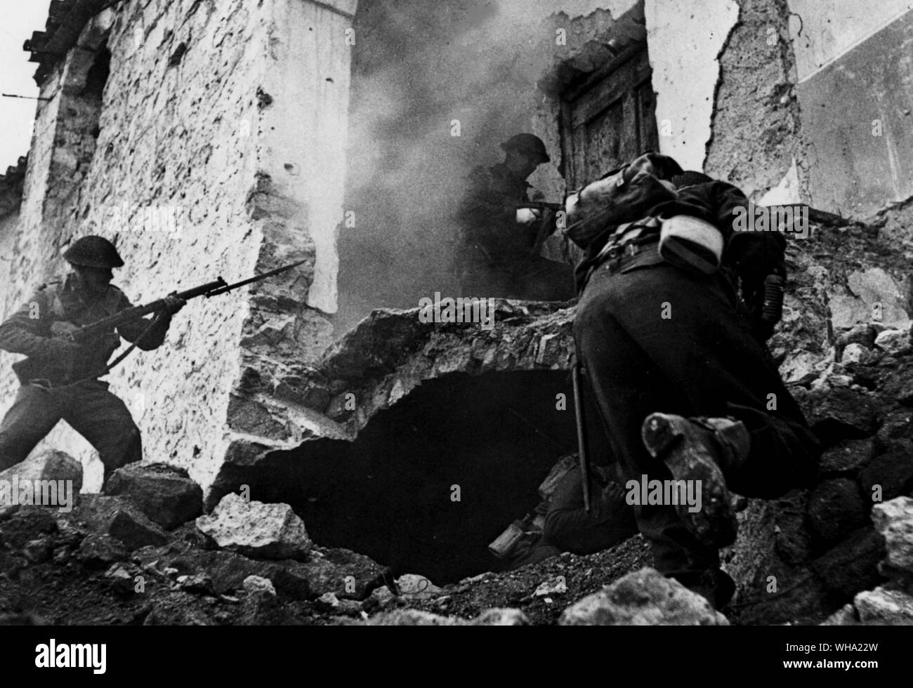 WW2: Every house that is not completely demolished in Cassino may contain snipers and these infantrymen of the allied forces search a partly demolished building. 24th March 1944. Stock Photo
