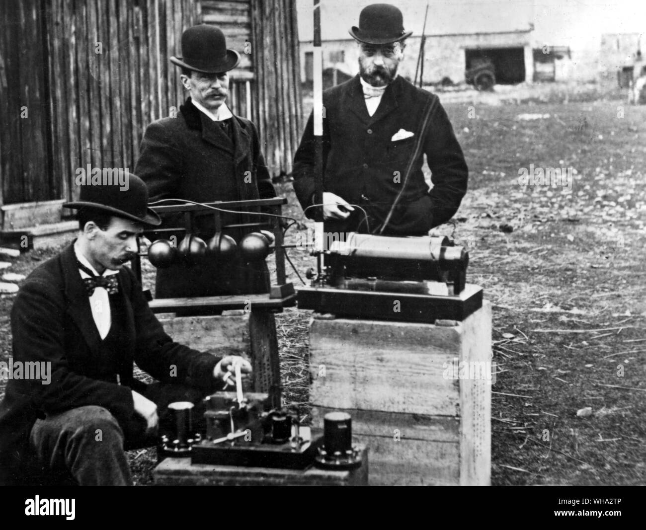 Post office officials examining Marconi's apparatus used to communicate by wireless eight miles across the Bristol Channel in 1897. The upper two pieces are a Righi spark gap (left) and an induction coil; below a Morse inker and relays Stock Photo