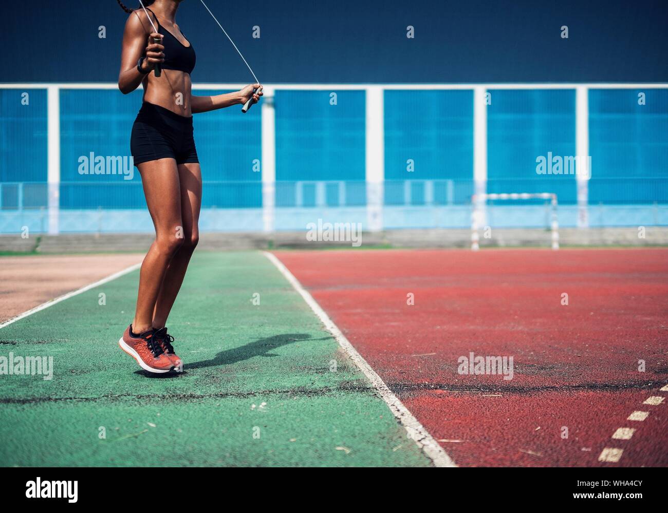 Woman Rope Skipping On A Sports Field Stock Photo