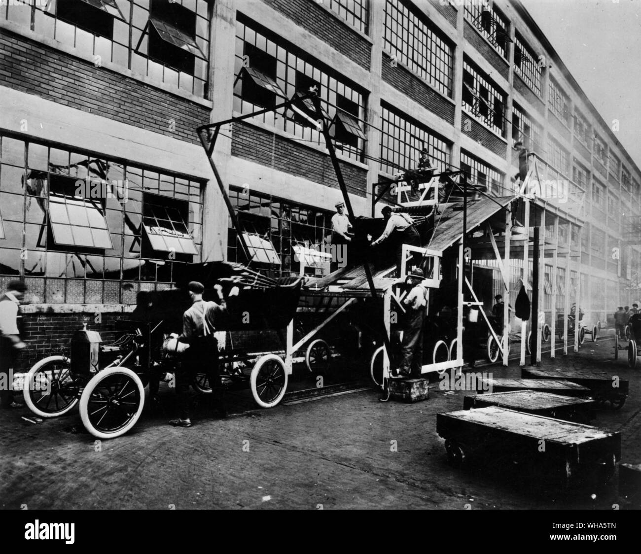 Body drop alongside Highland Park Plant . The cars are 1913 'Ts' Stock Photo