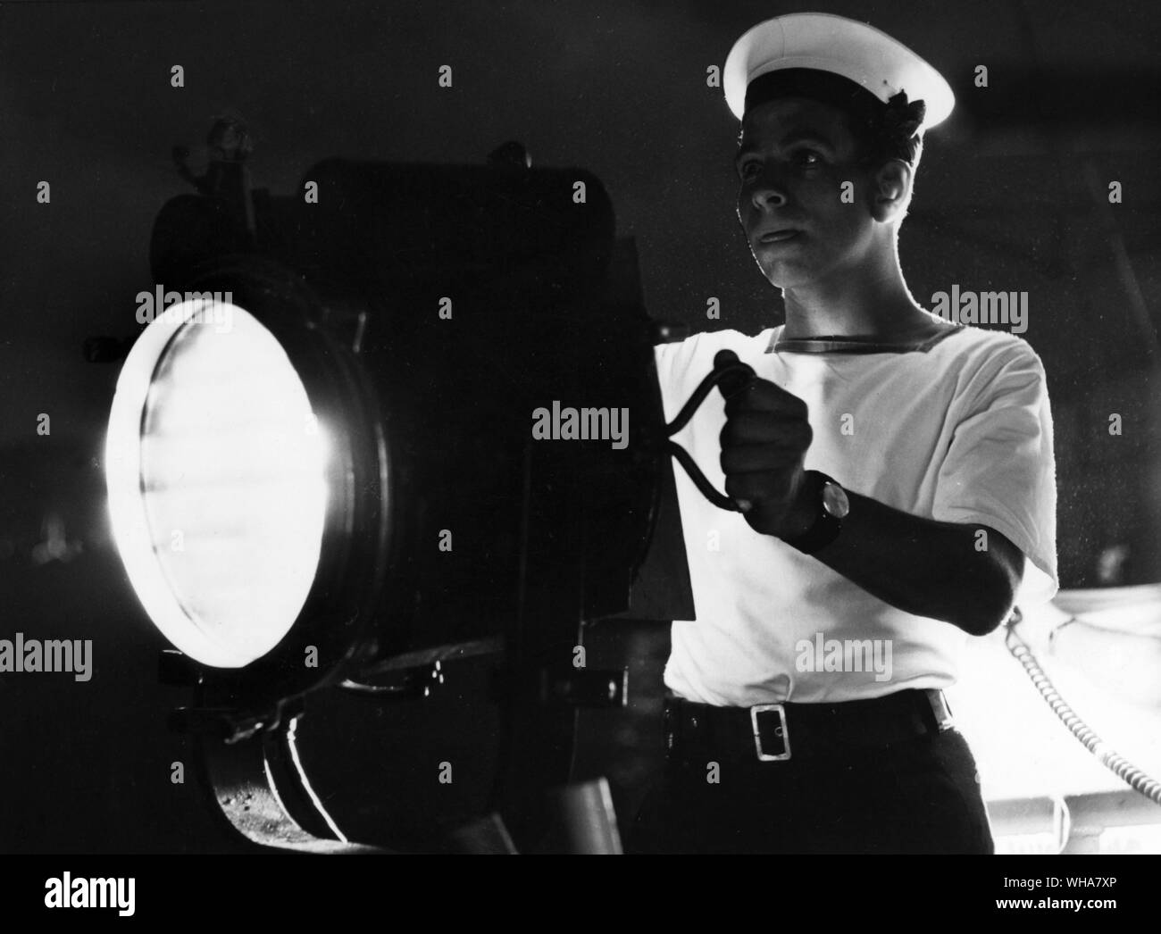 A river patrol, sailor operating signal lamp. The Royal Navy in Borneo Stock Photo
