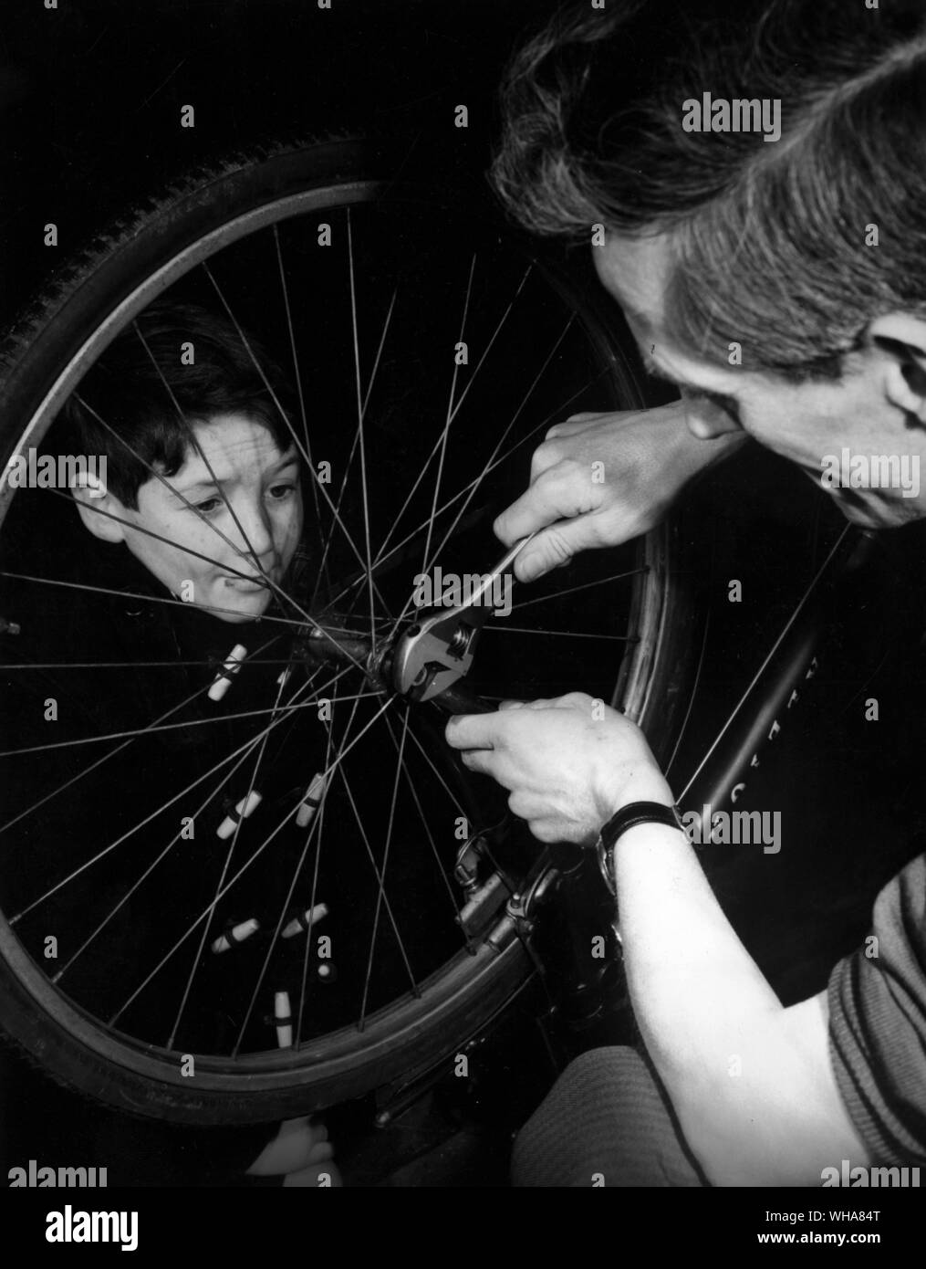 Man showing a boy how to fix his bike Stock Photo