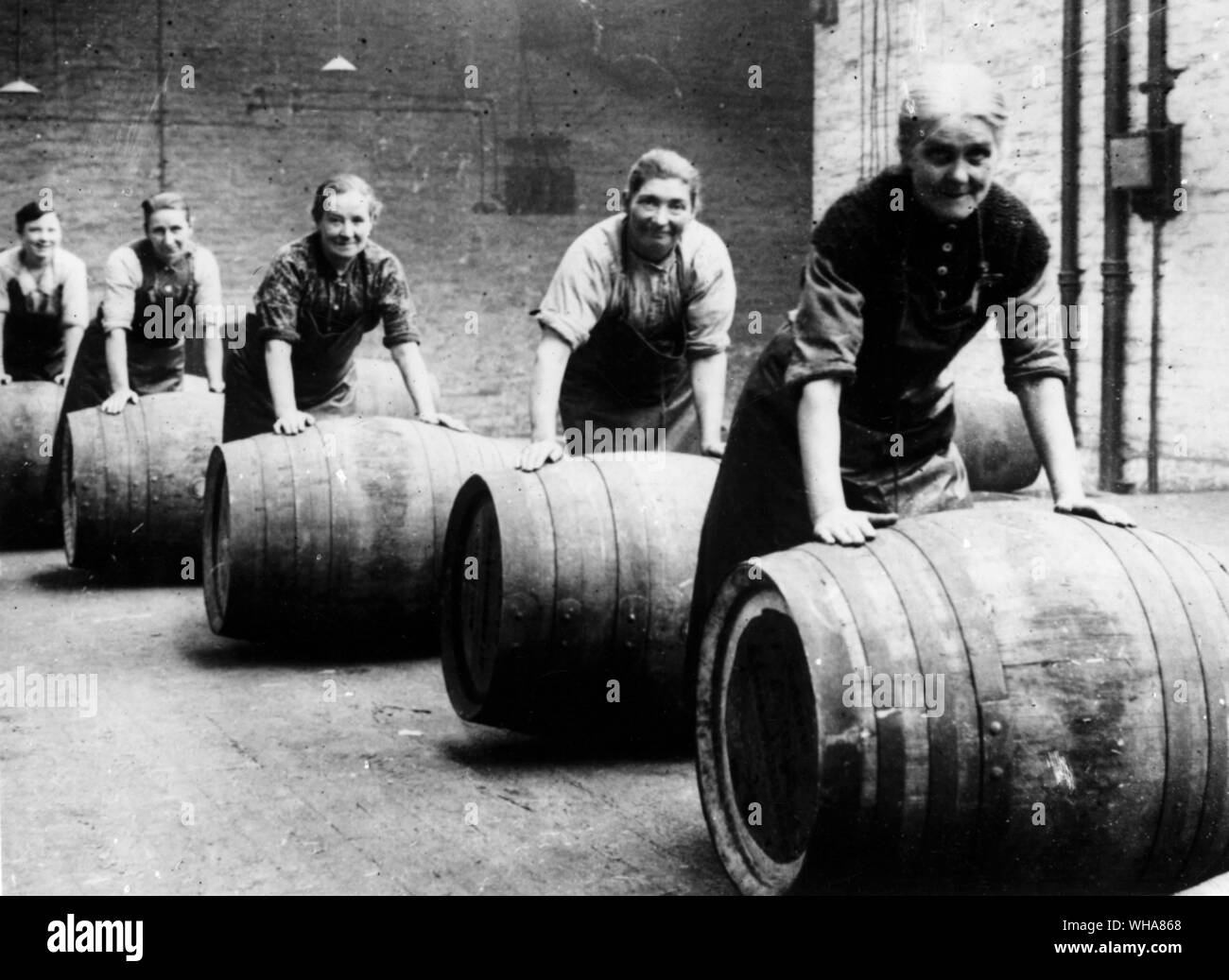 British women brewery workers in Cheshire. Bringing casks of beer to the railway waggons Stock Photo