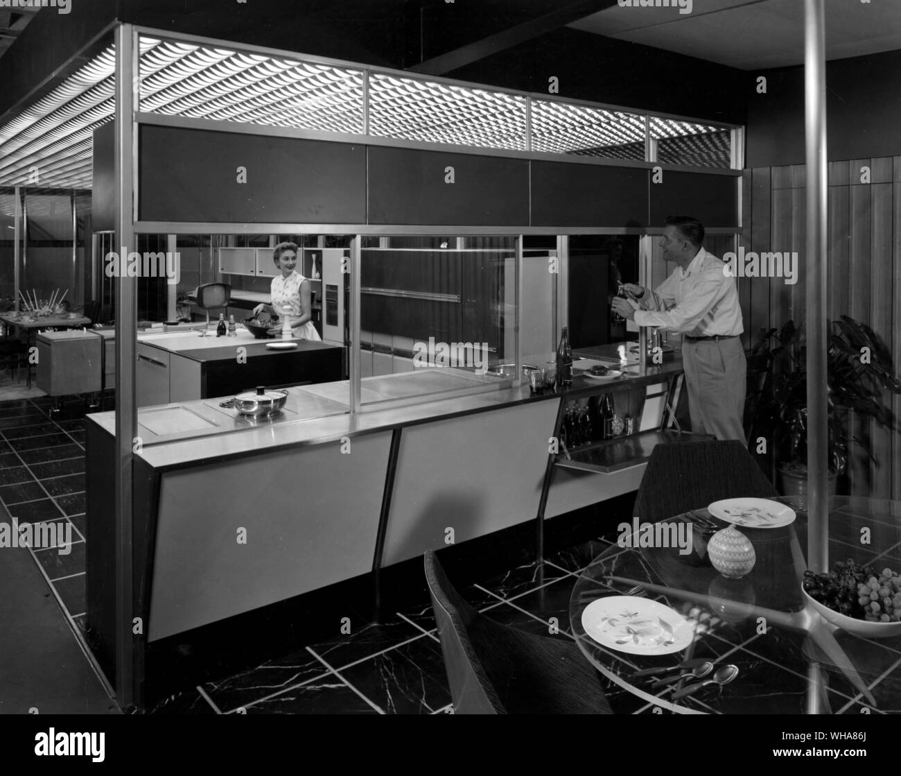 The ultimate in indoor outdoor living. Glass panels in Frigidaire's 1955 Kitchen of Tomorrow can be pushed aside opening patio to kitchen. Appliances such as oven and range surface units, can then be used and controlled from eithr inside or outside and there is a refrigerated bar built into the exterior wall of the house for patio use. Stock Photo