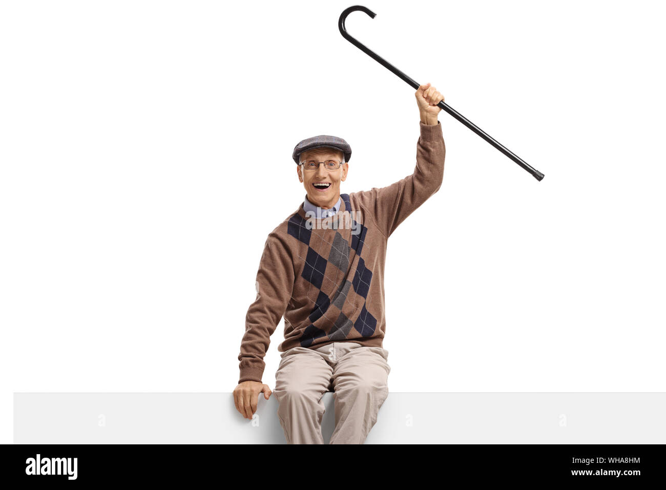 Happy elderly man with a cane sitting on a panel isolated on white ...