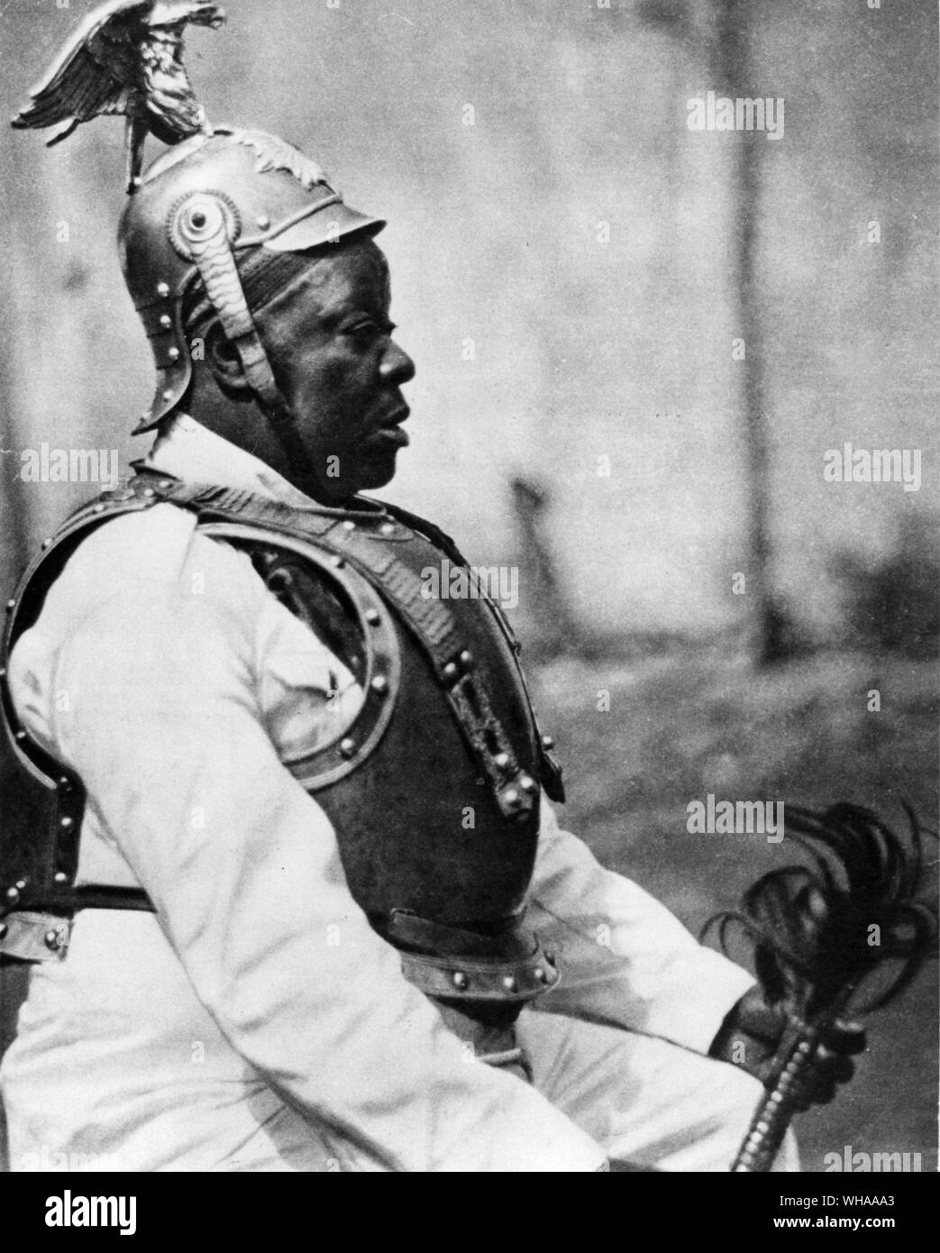 A native chief in the Cameroons taking part in a funeral wake wearing parts of a German uniform probably given to his father when the Cameroons were German Stock Photo