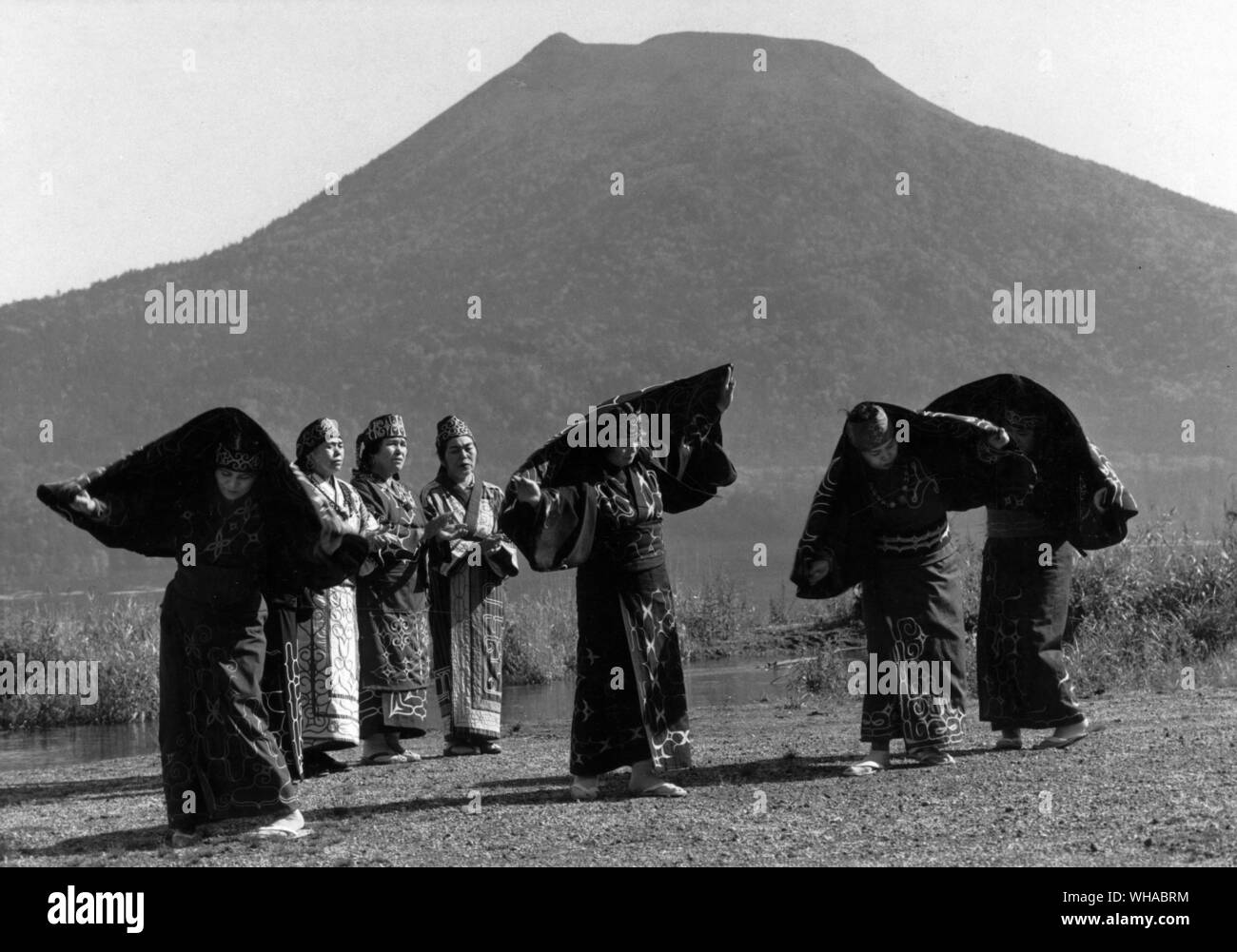 Ainu women dance the steps of the crane dance on the shores of Lake Akan, mimicking the cranes and weaving a charm to keep bears and other frightening creatures away Stock Photo