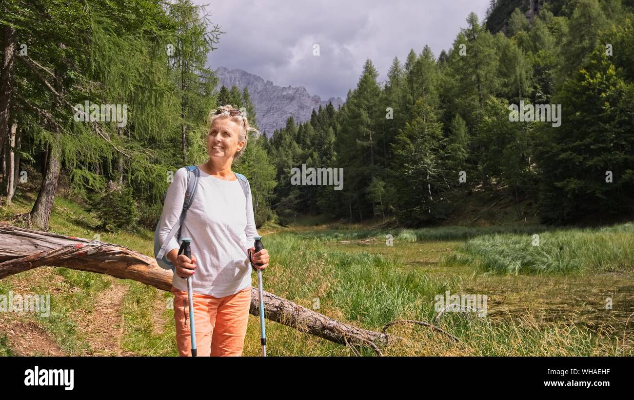 Woman hiker hiking looking at scenic view of mountain landscape . Adventure travel outdoors person standing relaxing  during nature hike Stock Photo