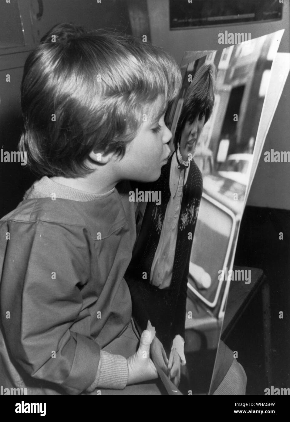 Scarlett Dyer, four, a pupil at the Pimlico kindergarten where Lady Diana teaches, kisses her picture today after her engagement to Prince Charles had been announced. Mr Michael Shea, the Queens secretary said that she would be giving up her job at the kindergarten. February 24th 1981 Stock Photo