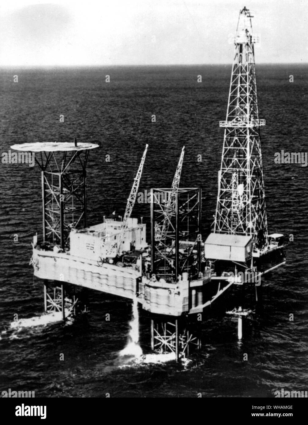 New Gulf Drilling Tower. The Vinegarroon, a huge offshore drilling tower, stands in the Gulf of Mexico, about 12 miles off shore from Cameron Louisiana. The unit was built by R G Le Torneau of Longview Texas for the Zapata off shore company of Houston at a cost of one and a quarter million pounds. The equipment can drill to a depth of 20,000 feet in water up to 100 feet deep. There is a heliport on a raised platform at the left.. 12th May 1957 Stock Photo