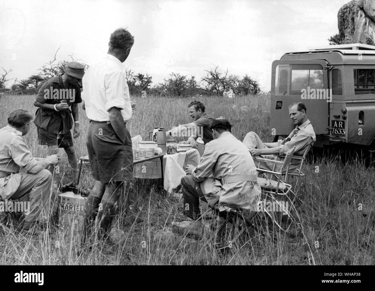 HRH Prince Philip in Serengeti National Park . December 1961. John Owen Director of Tanzania National Parks standing in shorts with his back to the camera Stock Photo