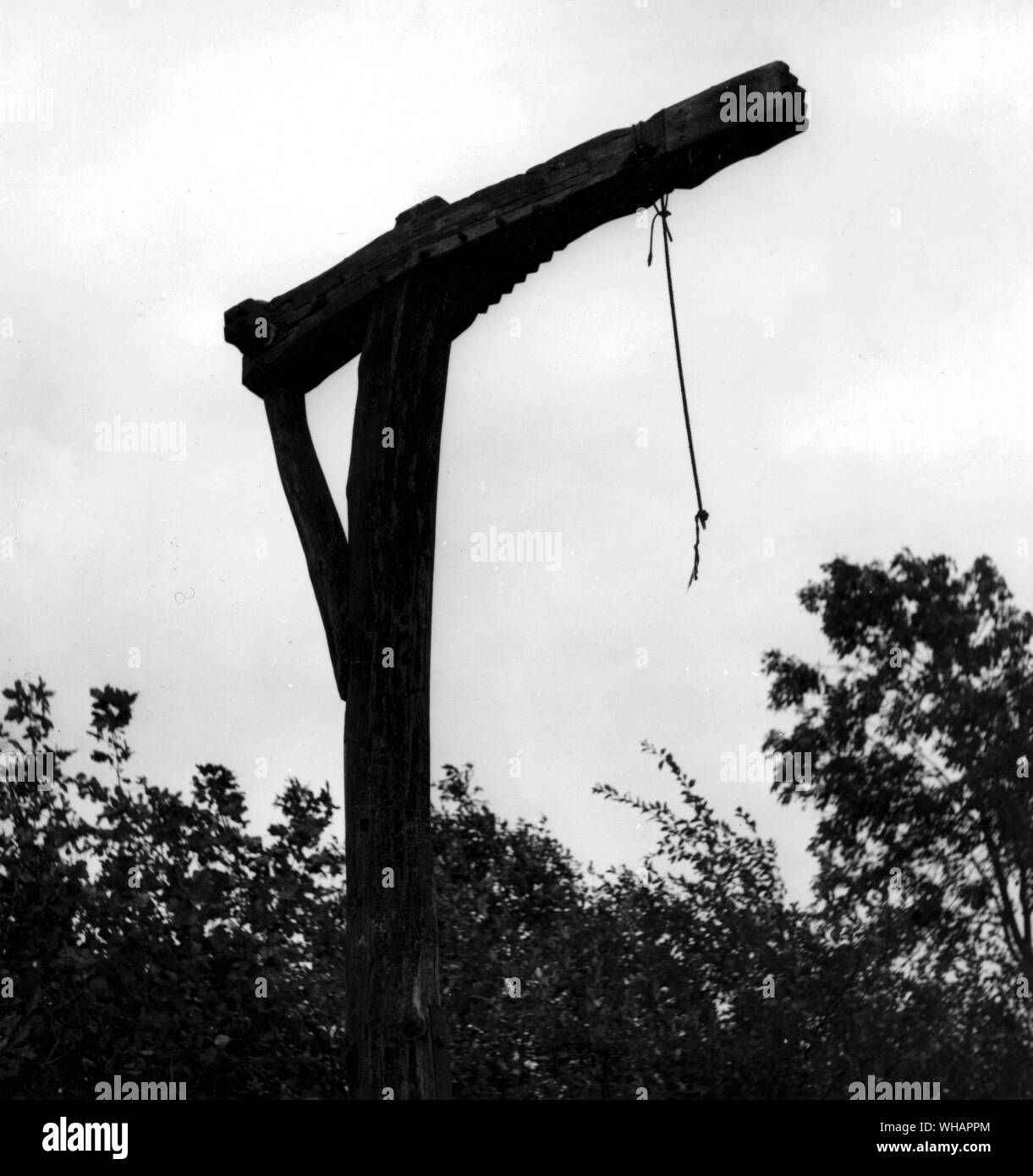 The Caxton Gibbet. Cambridgeshire. A mile and a half from Caxton, at what was the crossroads, there exists a replica gibbet, a grim reminder of the history of the place. Gibbeting was the punishment for some capital offences including highway robbery. An iron cage would have hung from the wooden arm of the original gibbet. Here criminals were hung, imprisoned in the cage until they were dead. The head was clamped at the top to prevent tired legs from resting and the person would slowly starve to death, or in the winter succumb to exposure. The body would remain suspended for some time after Stock Photo